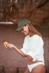 A model wearing Cove. caps in colour green perfect for everyday essentials