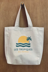White Les Tropiques tote bag with retro sun-and-palm print, Bali-inspired design