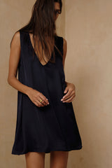 Model wears navy satin mini dress for day to night styling