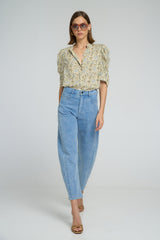 A woman wearing high waist light blue denim pant and floral top