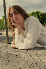 A woman wearing a white long sleeve blouse in Paris