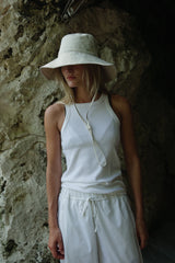 a girl wearing tank top and white hat