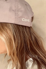 Details of Cove. logo on white colour caps in pale pink