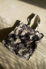 Durable oversized tote in brown tie-dye cotton resting on patterned rug.