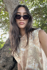 A woman wearing grey sunglasses on the beach
