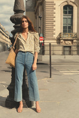 Model wearing wide-leg stretch denim jeans in pale blue with front patch pockets.