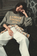 Model wears sweater in washed green ith jeans