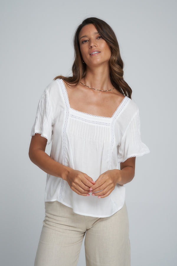 A Model Wearing a Feminine White Cotton Tops