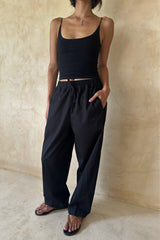 Woman wearing the Coconut Pants in Black with a relaxed straight-leg fit and elastic drawstring waist.