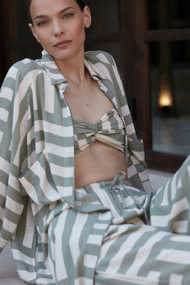 A woman wearing a green cover up for the beach