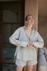 A model wearing a green/brown stripe cotton blouse