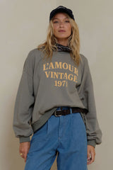 Model wears oversized crew neck vintage washed sweater with jeans
