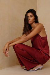 Model wears red sating pants with elastic fitted waist styled with a camisole top