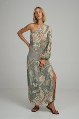 A model wearing a green floral one sleeve maxi dress by Lilya