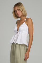 A woman wearing a white cotton halter top by Lilya