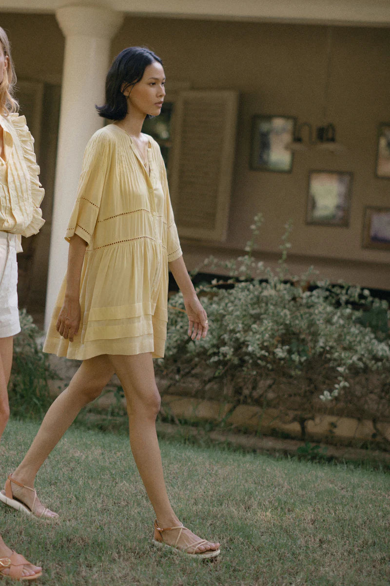 A model wearing a yellow boho mini dress by Lilya