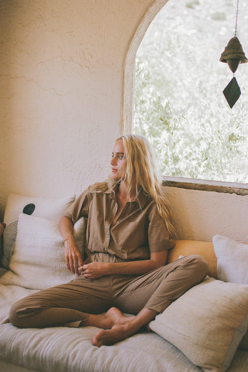 A model lounging wearing Marine jumpsuit in caramel colour by Lilya