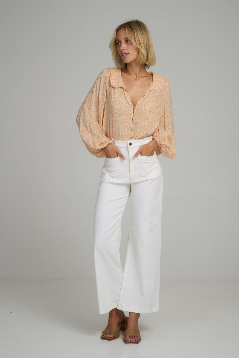 A woman wearing white high rise cotton pants