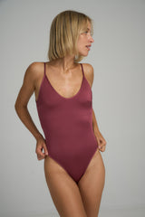 A model wearing a deep red one piece swimsuit in Australia by Lilya 