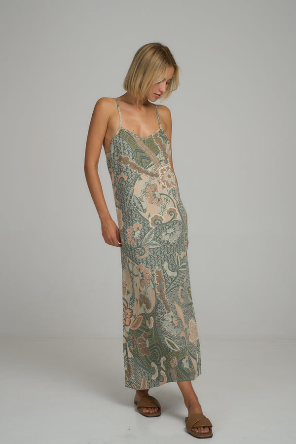 A model wearing a green batik 
floral maxi dress by Lilya 