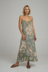 A model wearing a green batik print maxi dress by Lilya