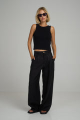 A model wearing classic black linen pants by Lilya