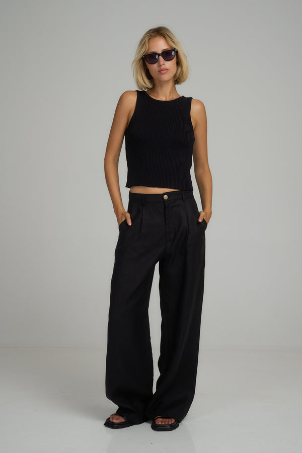 A model wearing classic black linen pants by Lilya