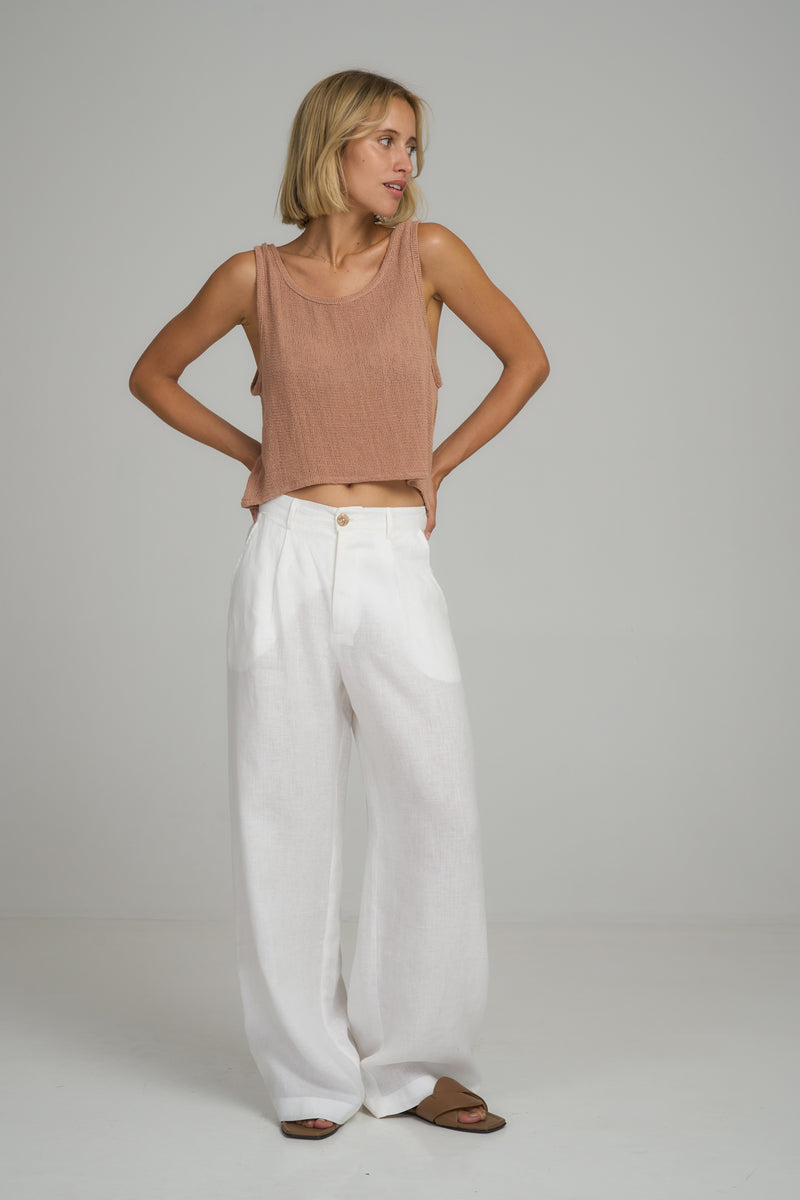 A woman wearing classic white linen pants by Lilya