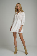 A model wearing the Tamara Mini Dress in Ivory by LILYA