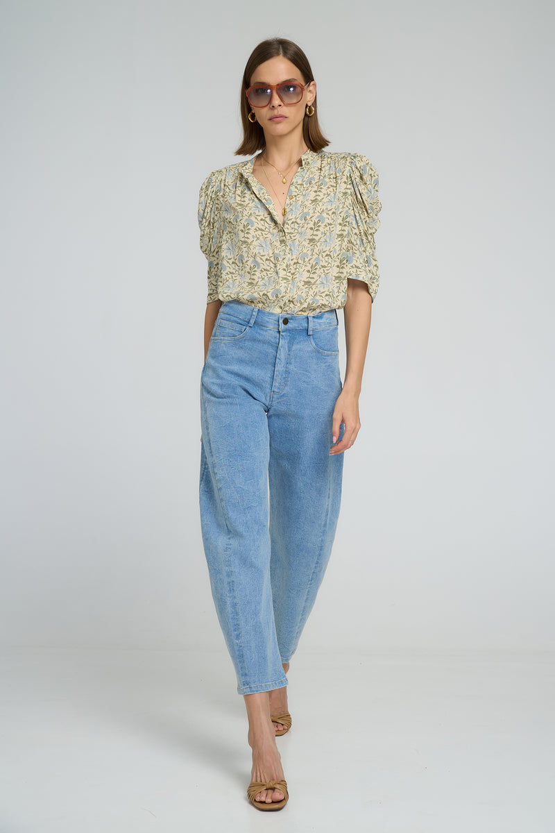 A woman wearing high waist light blue denim pant and floral top