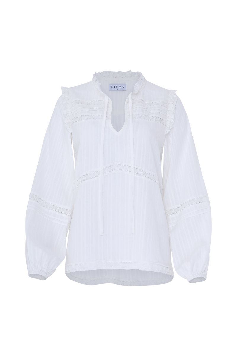 Romantic long sleeve top with front ties and lace detail.