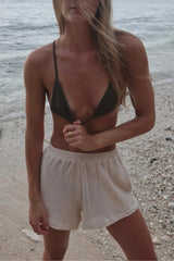 Model wears LILYA mesh shorts with sportswear look, styled with the Pacifica bikini at the beach