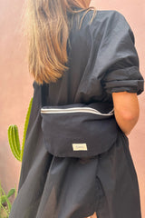 a women wearing cove. cross body bag in black color