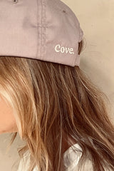 Details of Cove. logo on white colour caps in pale pink 