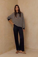 Model wearing the eessentia satin pants styled with a stripe knit top by LILYA