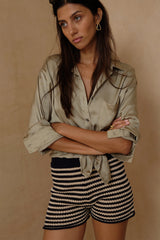 Model wears a satin shirt with stripe knit shrots for summer
