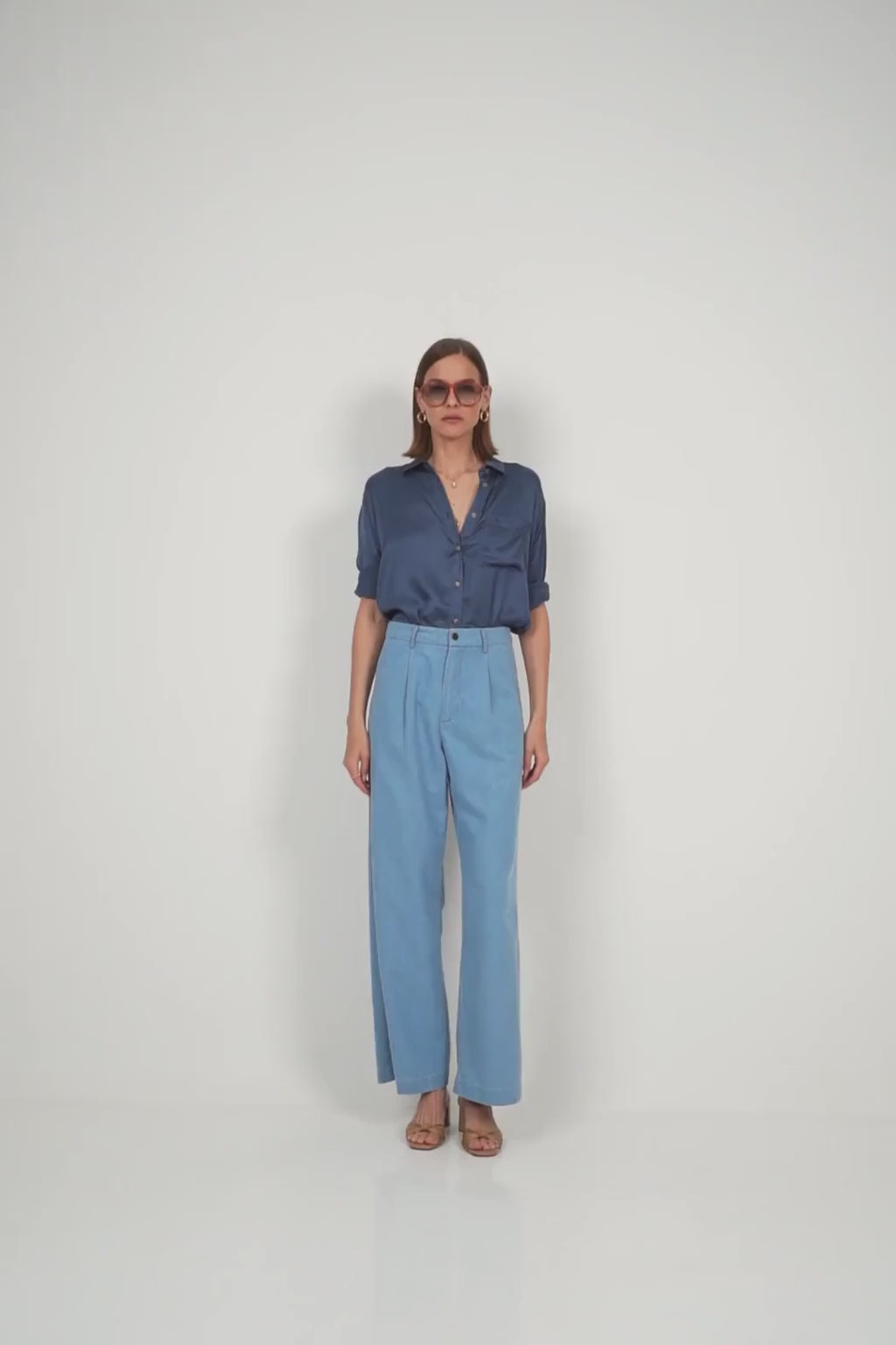 Model wears the LILYA soft rayon shirt in ocean tones tucked into light denim jeans.