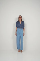 Model wears the LILYA soft rayon shirt in ocean tones tucked into light denim jeans.
