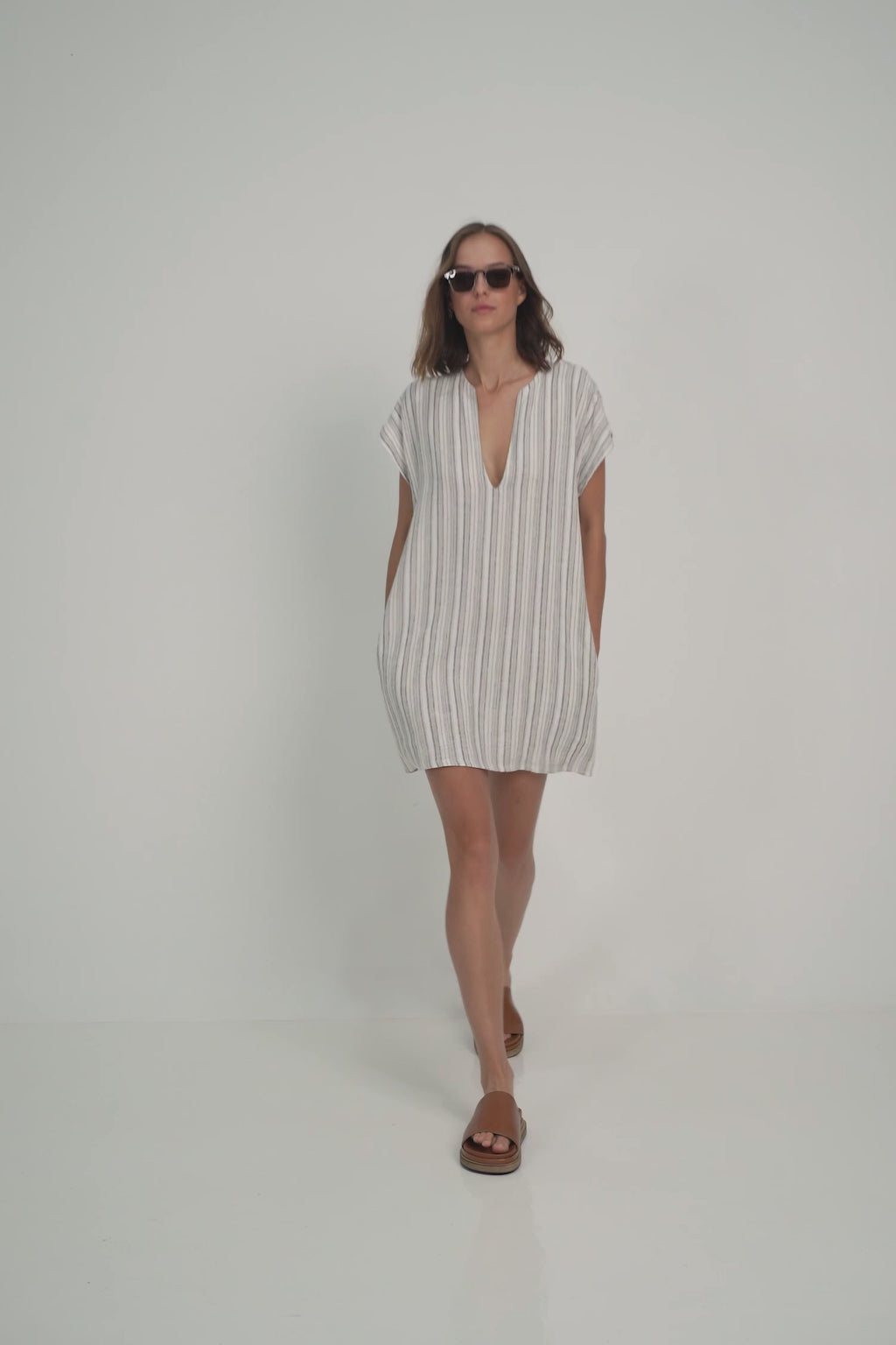 A Model Wearing a Short Linen Stripe Mini Dress for Summer by Lilya Australian brand