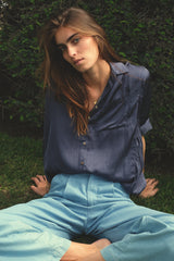 Model wears the LILYA lightweight viscose shirt with button front and curved back hem.