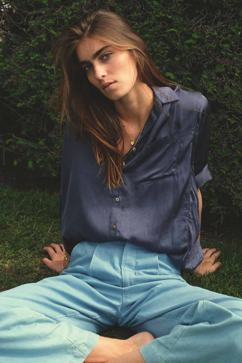 Model wears the LILYA lightweight viscose shirt with button front and curved back hem.