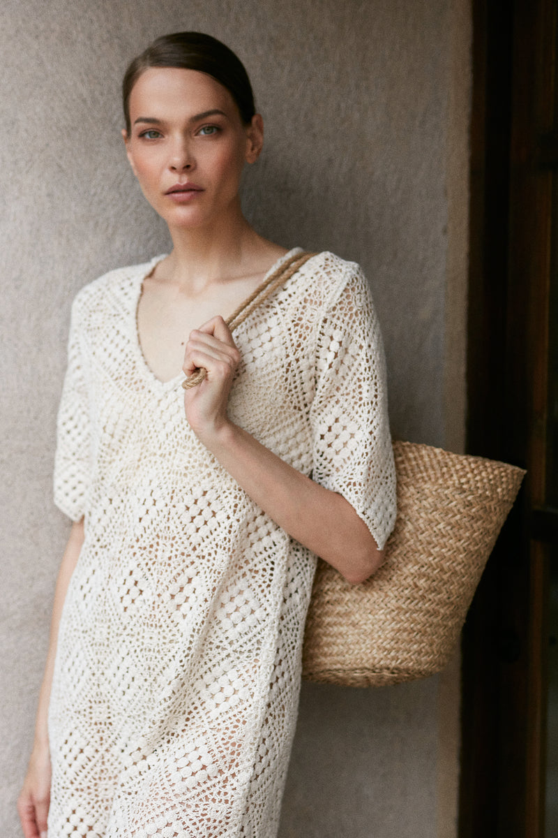 model wears rattan bag with dress