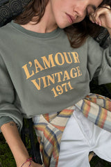 Close up photo of colleigate style flocked logo on green sweater