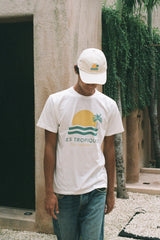 A man wearing les tropiques and les tropiques white hat