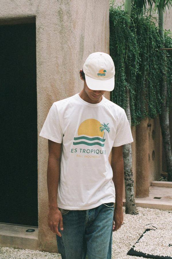 A man wearing les tropiques and les tropiques white hat