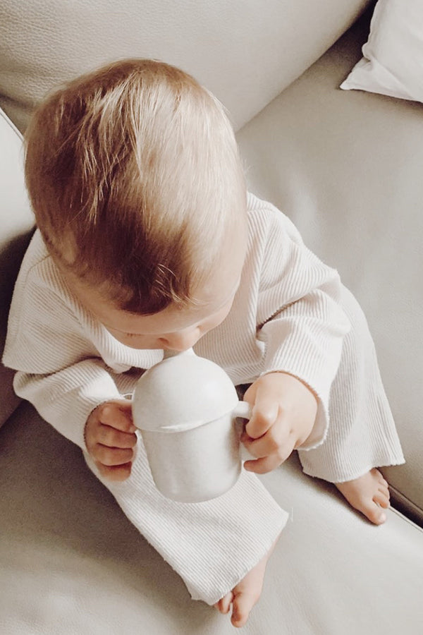 A baby with Wheat Straw Sippy Cup - Oat by Lion + Lamb